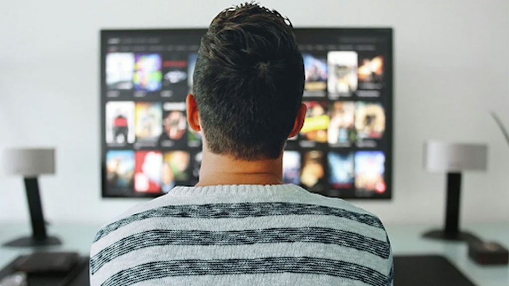 Man watching digital streaming on TV