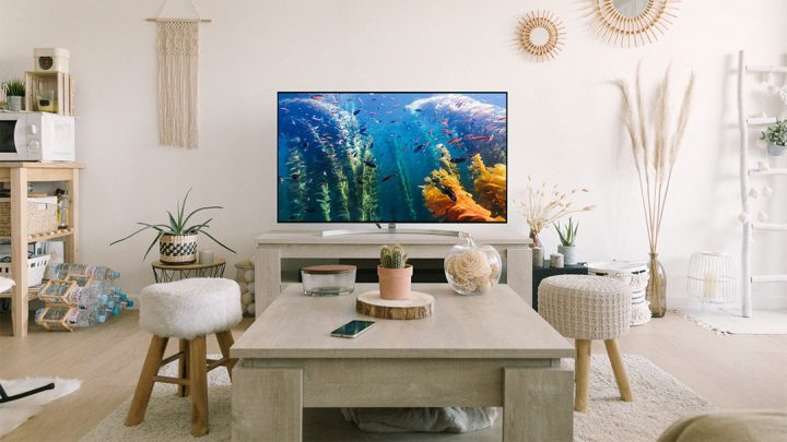 TV with brilliant screen showing ocean documentary in white living room.