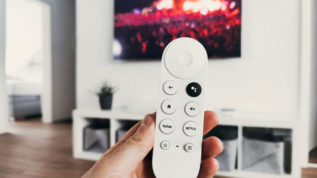 Hand holding a white TV remote
