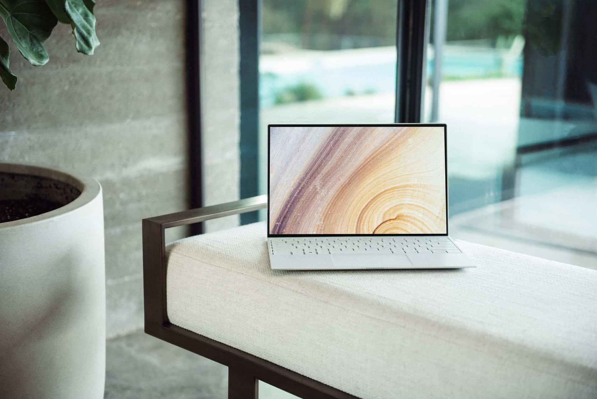 White laptop open on a cushioned bench