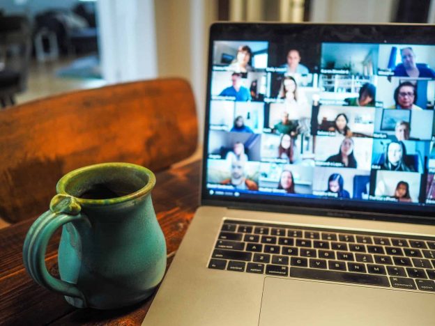 Laptop with gallery view of a video call with a mug