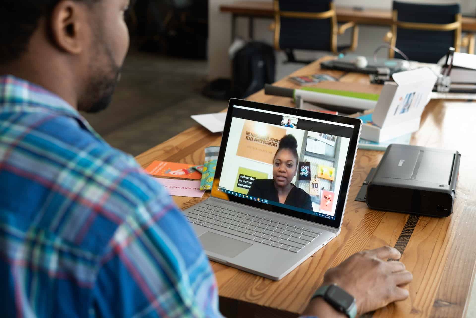 Man looking at his laptop in a video call with a woman