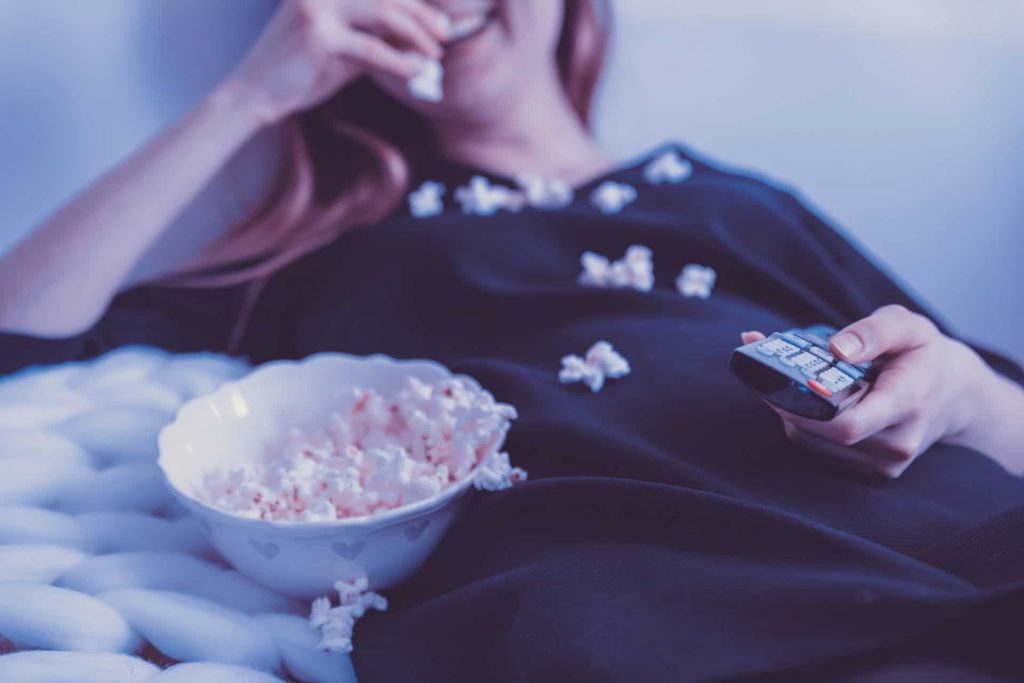 Woman eating popcorn and watching TV