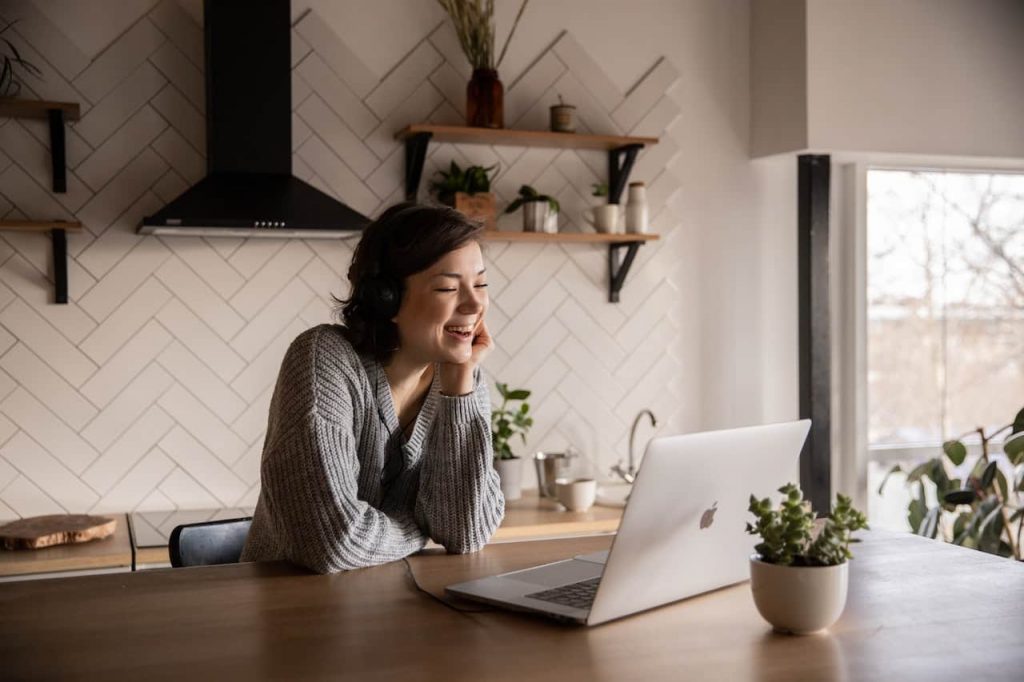 Woman smiling while on her laptop in the kitchen