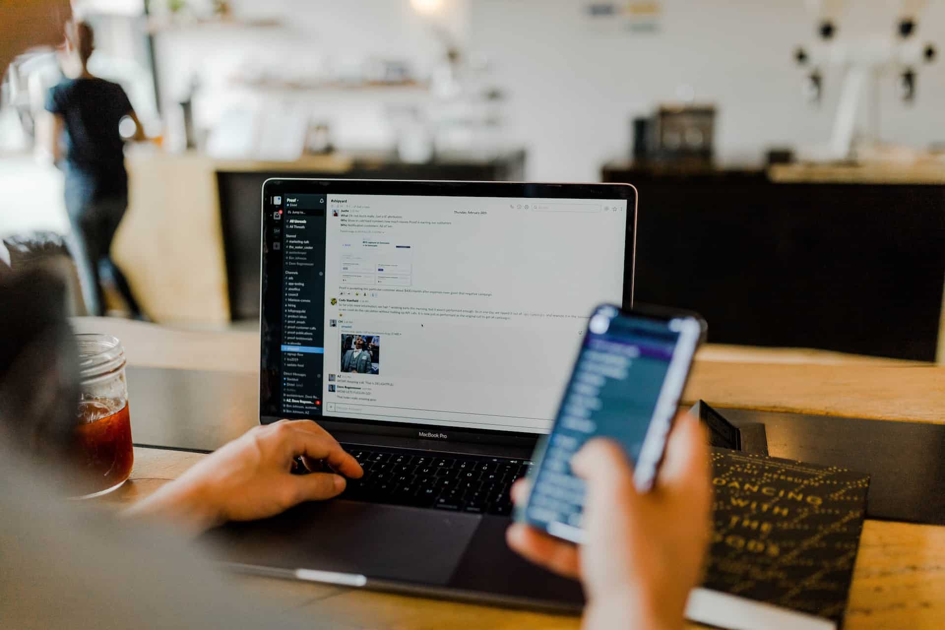 A person using a laptop and mobile phone