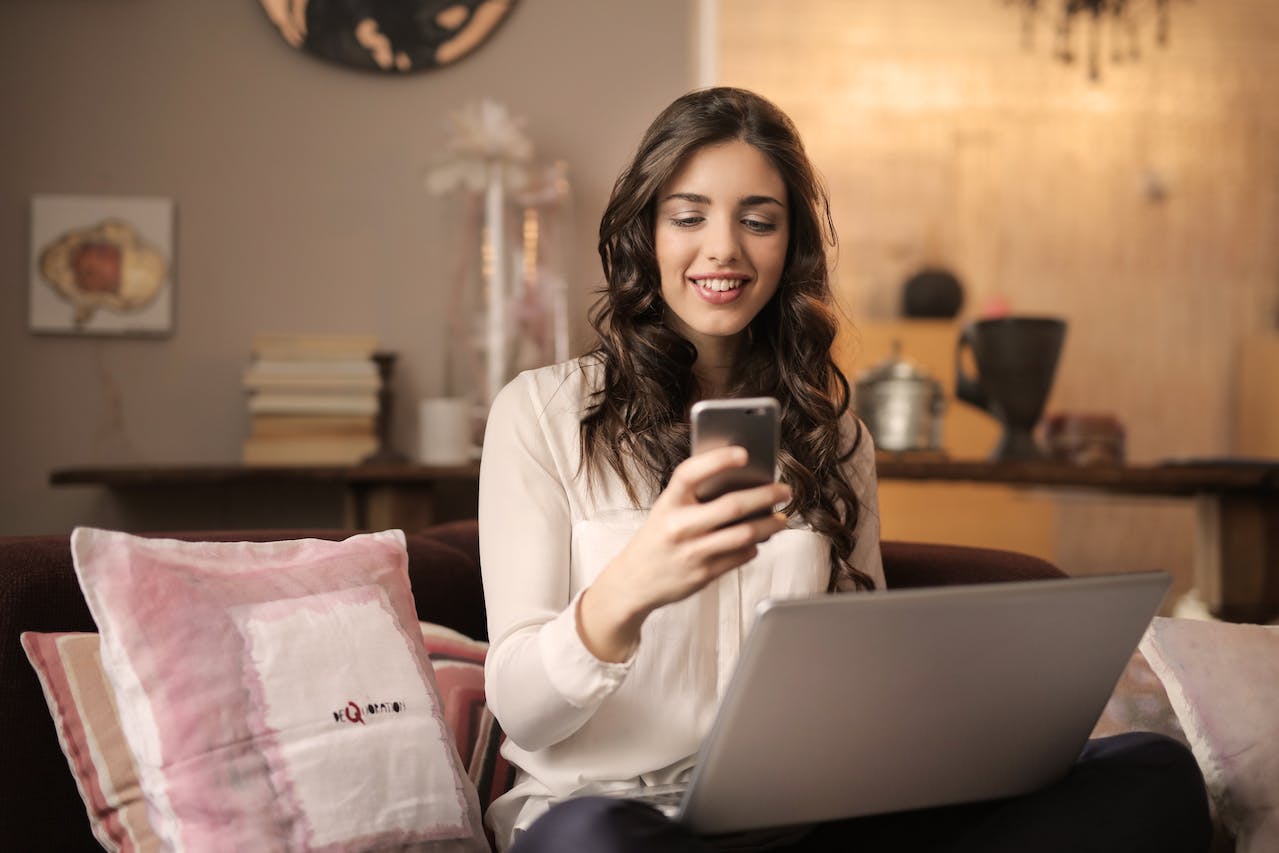 A woman using data on her cell phone and laptop