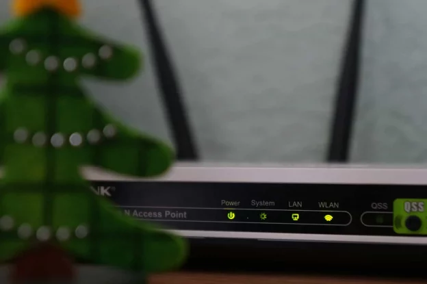 White and black modem router with four green lights on